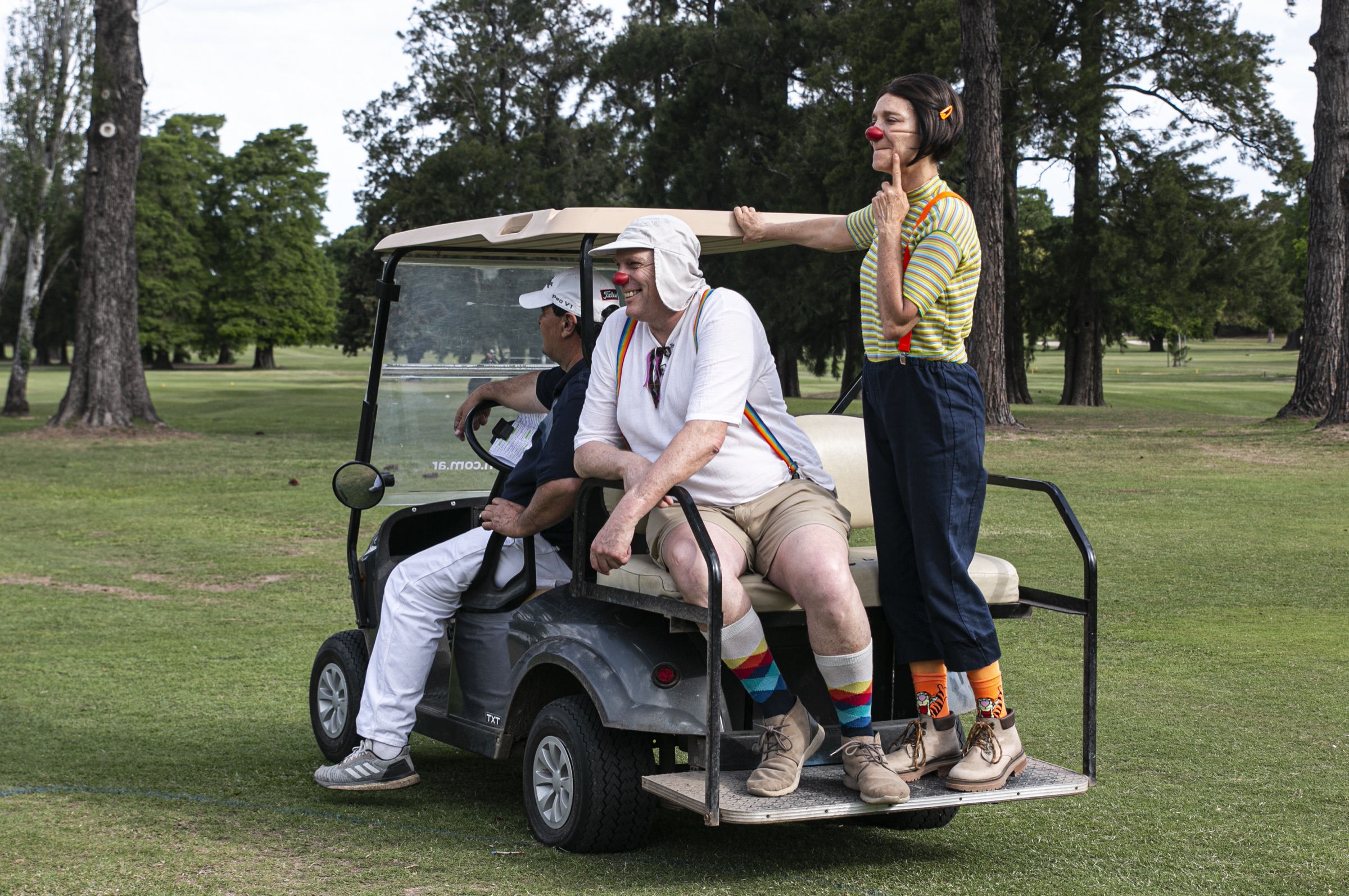 Payasos de Alegrañatas arriba de un carrito de golf durante la Copa